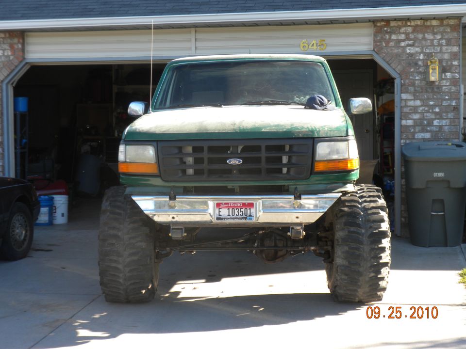 Front view of lifted green 1992 Ford F-150 with large off-road tires