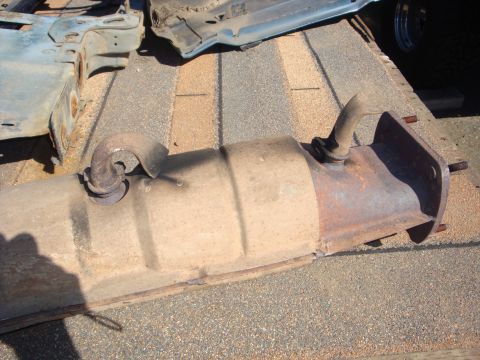 1989 Ford Bronco - Used exhaust catalytic converter with visible rust and wear, part of a vehicle teardown.