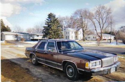 1990 Mercury Grand Marquis - A 1990 Mercury Grand Marquis is parked in front of a suburban neighborhood.
