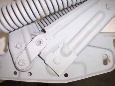 1970 Chevrolet Camaro - This close-up shows a gray-painted hood hinge assembly with a visible spring and mechanical components.