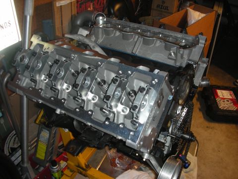 1992 Ford Crown Victoria - Engine block and cylinder heads on a stand, showing intricate valvetrain details and timing chain mechanisms.