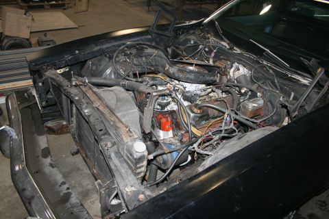 1973 Ford Ranchero - The engine bay of a black vehicle is shown, with the hood open and the engine and radiator exposed.