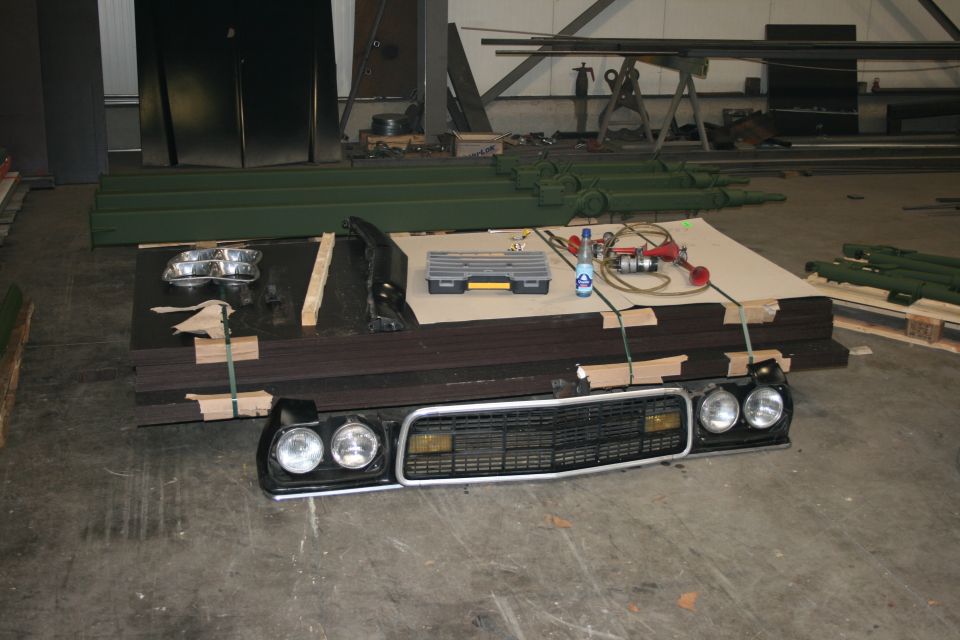 1973 Ford Ranchero grille and headlight assembly laid out on floor with tools