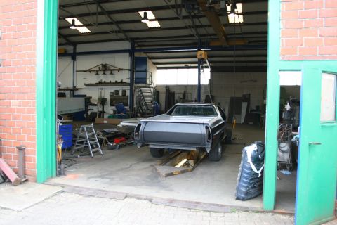 1973 Ford Ranchero - 1973 Ford Ranchero undergoing repairs in a workshop. Rear view shows the vehicle on a lift.