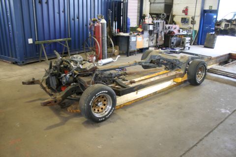 1973 Ford Ranchero - Chassis of a 1973 Ford Ranchero, complete with engine and exhaust, undergoing work in a garage.