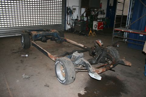 1973 Ford Ranchero - This vehicle chassis is in a workshop, appearing to be undergoing repairs or a rebuild. The front wheels are visible.