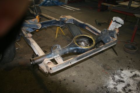 1973 Ford Ranchero - The rear axle and frame of a vehicle are disassembled and supported by stands in a garage setting.