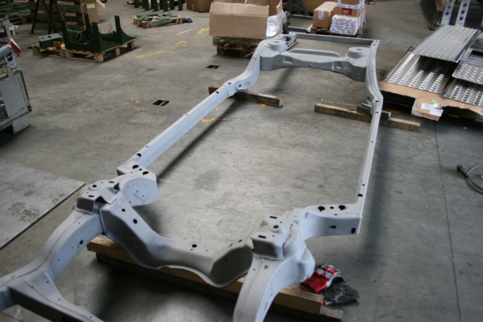 Vehicle frame on wooden blocks in a workshop