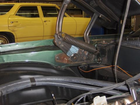 1970 Chevrolet Camaro - Close-up of a green car's engine bay with a yellow station wagon visible in the background.