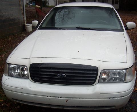 2002 Ford Crown Victoria - Front view of a white 2002 Ford Crown Victoria parked outdoors.