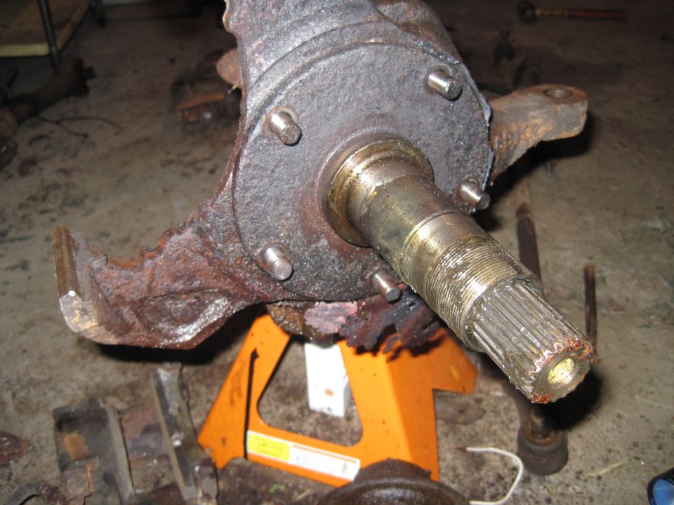 rusted vehicle spindle assembly on orange jack stands