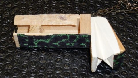 1978 Ford Bronco - A homemade wooden object with fabric and paper elements is shown against a textured black background.