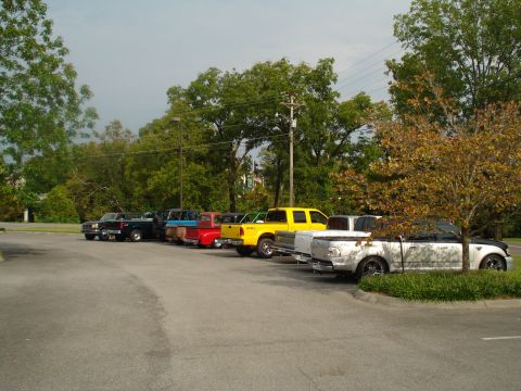 1994 Ford F-350 - Several pickup trucks are parked in a lot under a cloudy sky.
