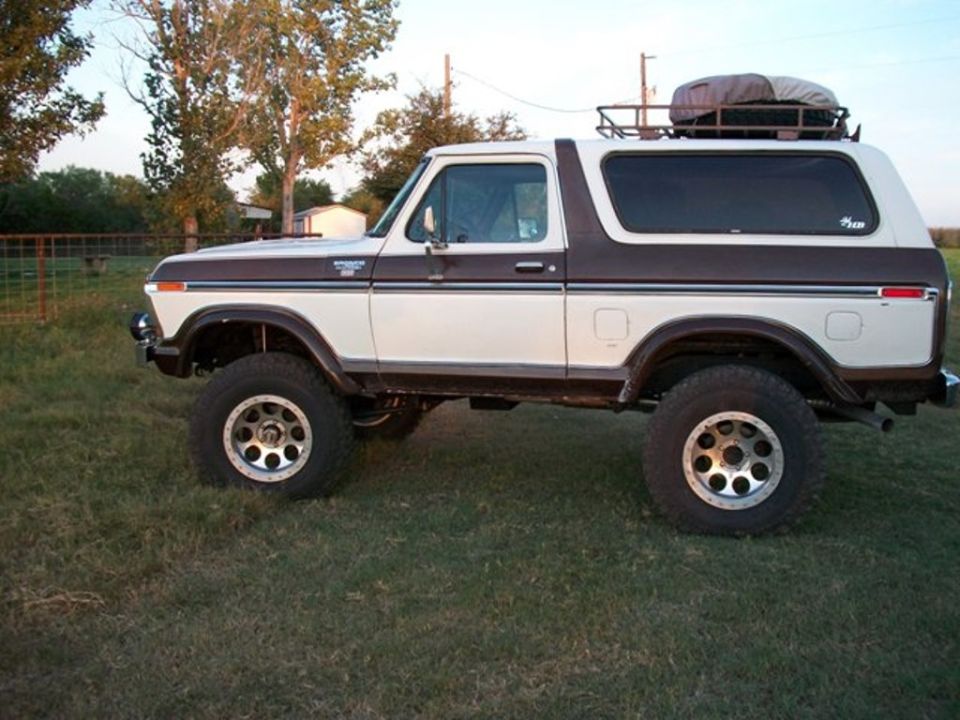 White and brown 1978 Ford Bronco with a roof rack and cargo carrier, lifted suspension, and aftermarket wheels