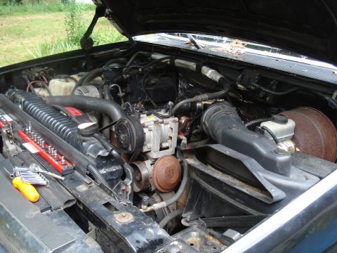 1994 Ford F-350 - Tools are laid out on the radiator of a truck's engine bay, ready for work.