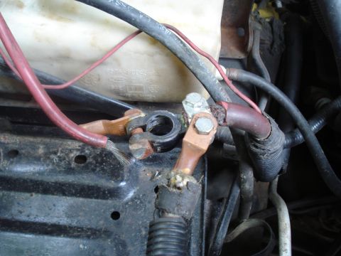 1994 Ford F-350 - Close-up of corroded battery terminals and frayed wiring in the engine bay of a 1994 Ford F-350.