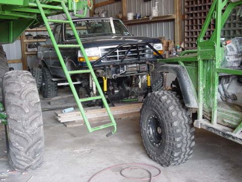 1992 Ford Bronco - A 1992 Ford Bronco is parked indoors, partially obscured by a green ladder and another vehicle.