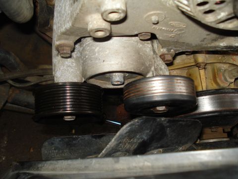 1994 Ford F-350 - Close-up view of engine pulleys and fan, with a Ford logo visible on the engine block.