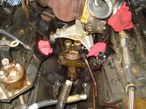 1994 Ford F-350 - Close-up view of engine components, including a fuel filter and turbocharger, with red rags used to plug openings.