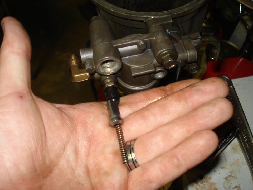 hand holding a fuel filter housing with a metal line attached