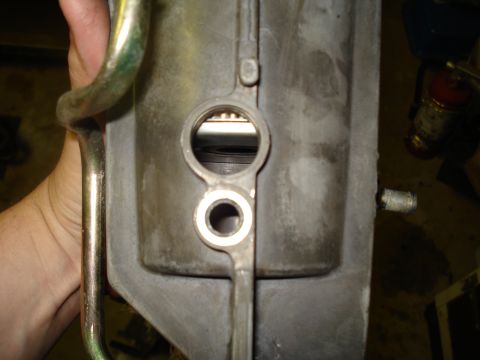1994 Ford F-350 - Close-up of an engine part, showing internal components through circular openings. A hand is visible holding a metal pipe.