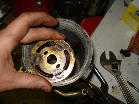 1994 Ford F-350 - Disassembled engine part held by a hand, with tools visible on a workbench.