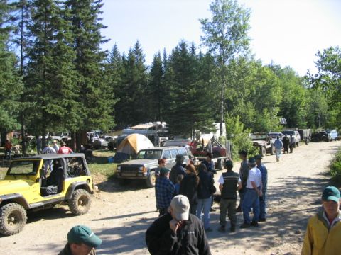 1986 Ford Bronco - Multiple off-road vehicles and tents are visible at an outdoor gathering.