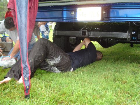 1994 Ford F-350 - Someone is working on the rear axle of a truck while others stand by.