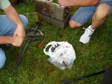 1994 Ford F-350 - Several individuals are seen working on car parts laid out on a grassy area next to an open toolbox.