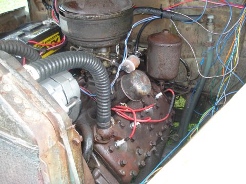 1994 Ford F-350 - Close-up view of an engine bay, showing the V8 engine block, carburetor, and a complex wiring harness.