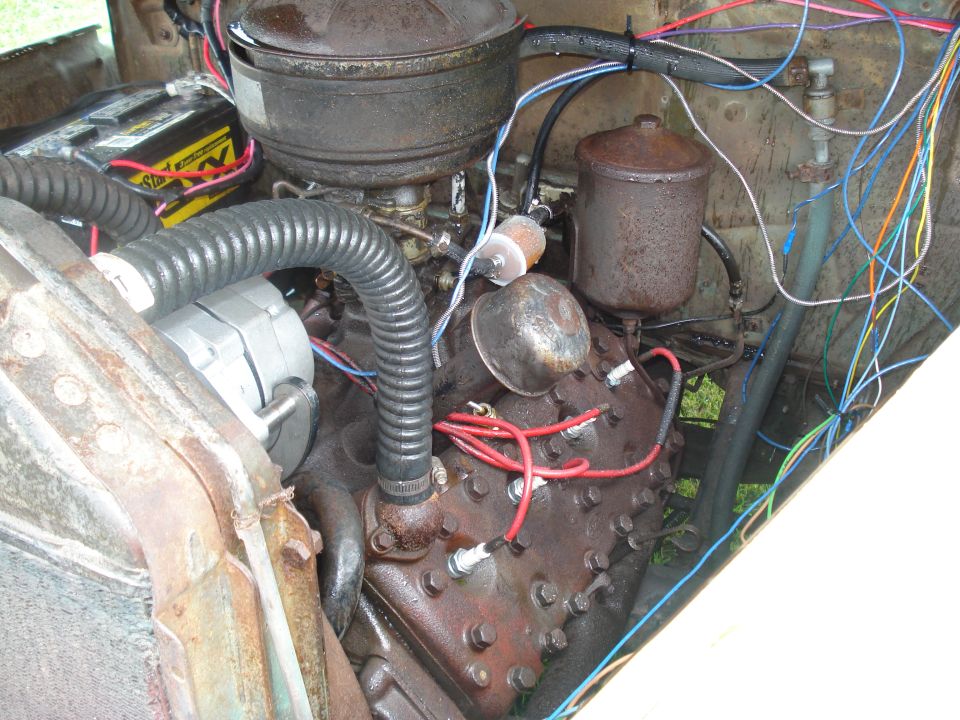 Engine bay with a V8 engine, battery, alternator, and extensive wiring