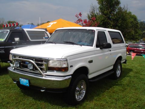 1994 Ford F-350 - A white Ford Bronco is parked on grass with tents and other vehicles in the background.