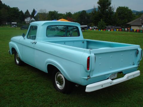 1994 Ford F-350 - A light blue 1956 Ford F-100 pickup truck is parked on a grassy field.