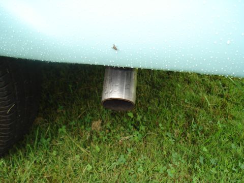1994 Ford F-350 - A close-up view of a vehicle's fender and exhaust pipe, with water droplets visible on the paint.