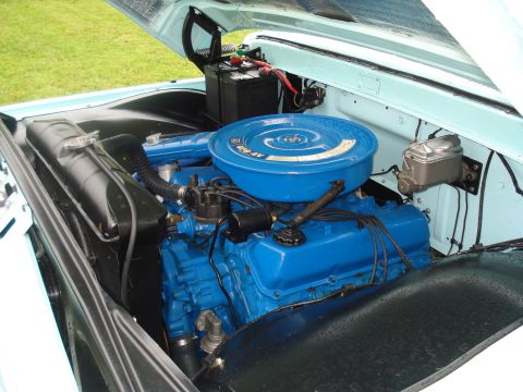 1994 Ford F-350 - The engine bay of a light blue truck features a bright blue V8 engine with a round air cleaner and visible battery.