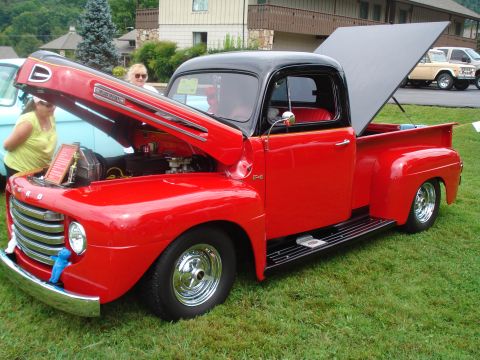 1994 Ford F-350 - A classic red 1950s Ford F-1 pickup truck is displayed with its hood and bed open.
