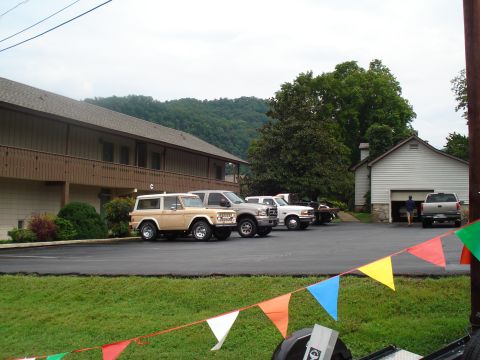 1994 Ford F-350 - Several vehicles are parked in a lot near a building with a garage. A person is walking towards the garage.
