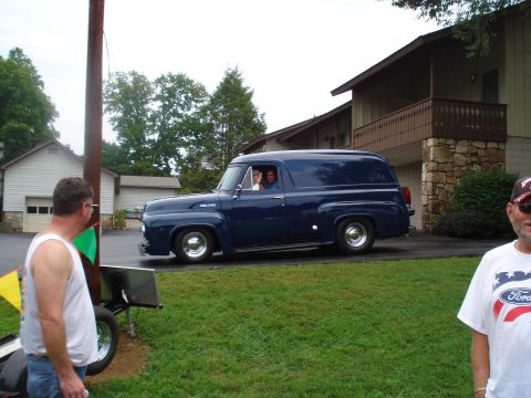 1994 Ford F-350 - A dark blue 1953 Ford panel van is seen driving on a suburban street.