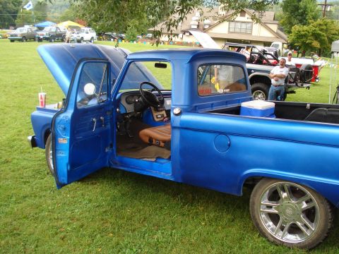 1994 Ford F-350 - A blue pickup truck is parked on grass with its hood and driver's door open, its interior.