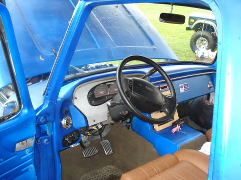 1994 Ford F-350 - Interior view of a blue 1992 Ford F-150, showing aftermarket modifications and a second vehicle in the background.