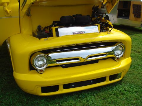 1994 Ford F-350 - Front view of a yellow 1956 Ford F-100 truck with the hood open, revealing the engine.