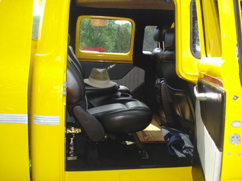 1994 Ford F-350 - Interior view of a yellow truck, black leather seats, a hat, and a trophy on the floor.