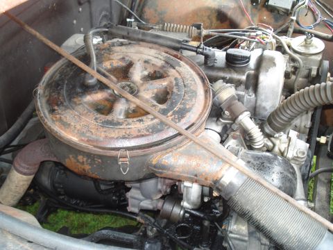 1994 Ford F-350 - Close-up view of a vehicle's engine bay, showing various mechanical parts and the air filter assembly.