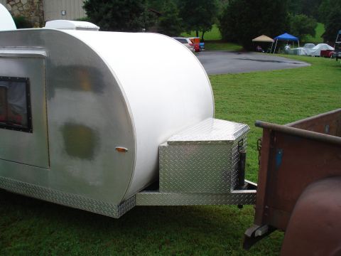 1994 Ford F-350 - A teardrop trailer is hitched to the back of a rusty, vintage truck.