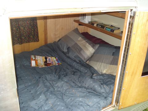 1994 Ford F-350 - The interior of a camper bed is shown with a magazine lying on the covers.
