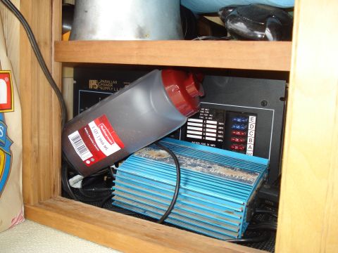 1994 Ford F-350 - Close-up of electrical components and a bottle inside an RV's storage compartment.