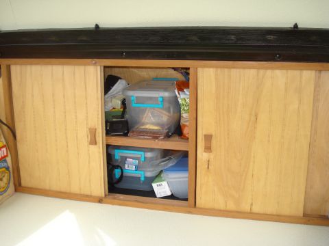 1994 Ford F-350 - Storage cabinets with sliding doors, containing various plastic bins and items on shelves.