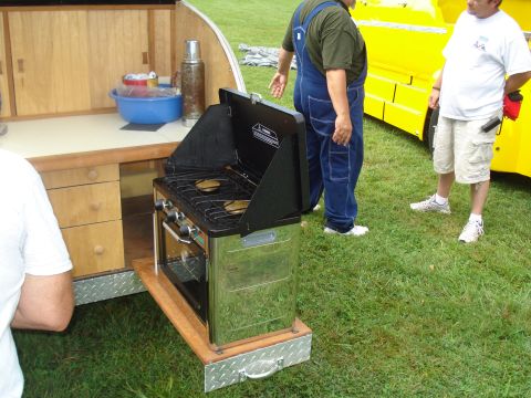 1994 Ford F-350 - An outdoor kitchen setup is shown with a propane stove and oven, two men, and a yellow vehicle.