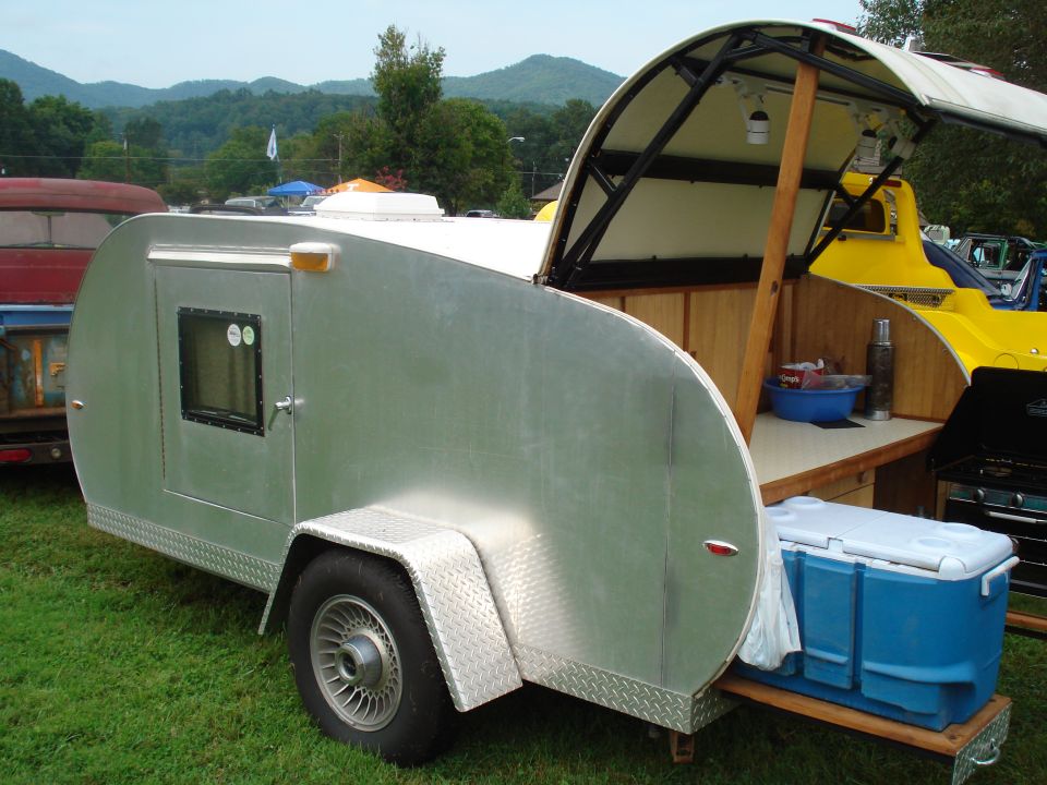 Aluminum teardrop trailer with open galley kitchen and blue cooler