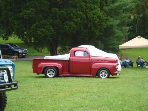 1994 Ford F-350 - Classic red pickup truck with a cover on the bed is parked on a grassy field.